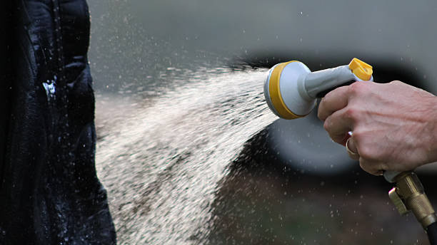 istock A person rinses an item outside with a multi-pattern hose nozzle 2236278304