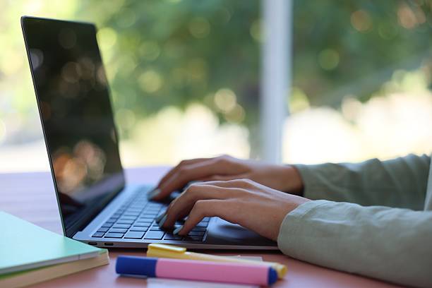 istock Woman working with laptop at table against blurred background, closeup 2236278569