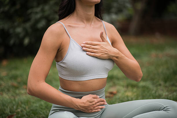 istock Woman sitting on yoga mat doing breathing exercises 2236278574