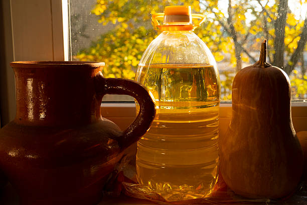 Pumpkin, a vessel with fresh sunflower oil and a jug in the warm tones of evening sunlight.