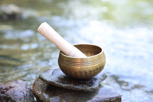 istock Tibetan singing bowl with mallet on stone near river, closeup 2236279468
