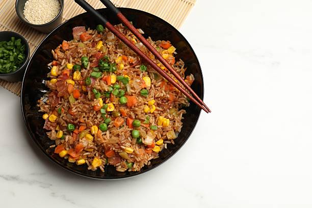 istock Tasty fried rice and chopsticks on white marble table, flat lay. Space for text 2236279806