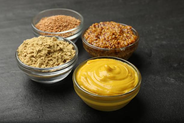 istock Different types of mustard on black table, closeup 2236279904