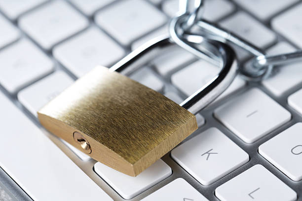 Cyber safety. Metal padlock and chain on computer keyboard, closeup