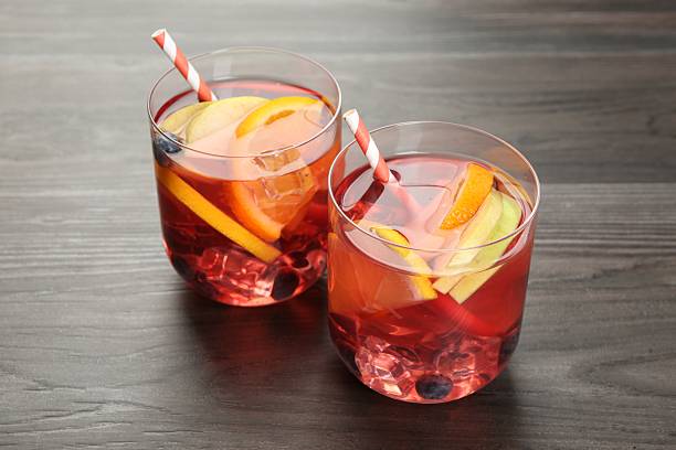 istock Fruity punch in glasses on wooden table, closeup. Refreshing drink 2236280555