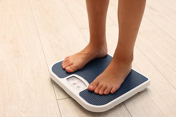istock Little boy standing on scales indoors, closeup. Space for text 2236280654