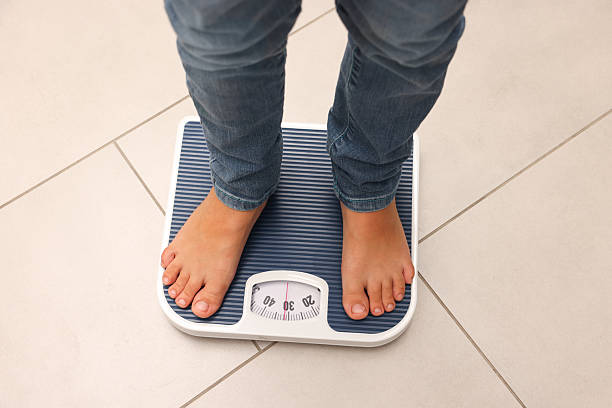 istock Little boy standing on scales indoors, above view 2236280710