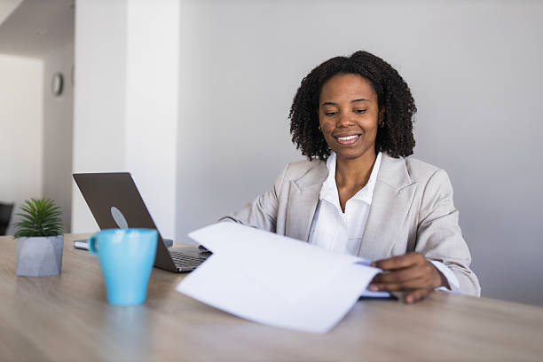 istock Black businesswoman smiling working with documents in office 2236281496