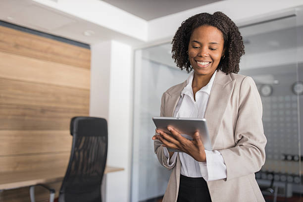istock Black businesswoman smiling using digital tablet in office 2236281529