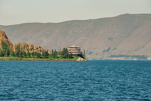 Sevan, Armenia - July 29, 2012 - Scenic lakeside view with mountains and modern house at sunset.
