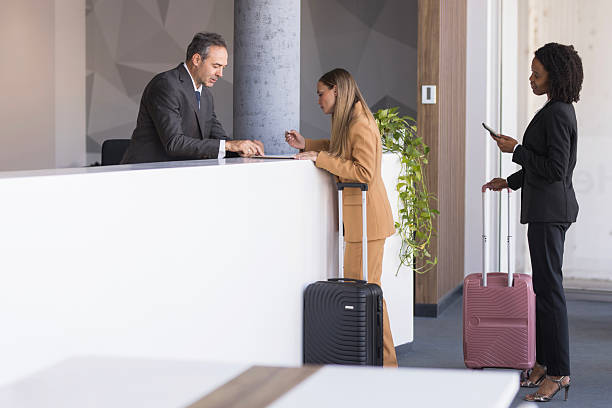 istock Business travelers checking in at hotel reception desk 2236285294