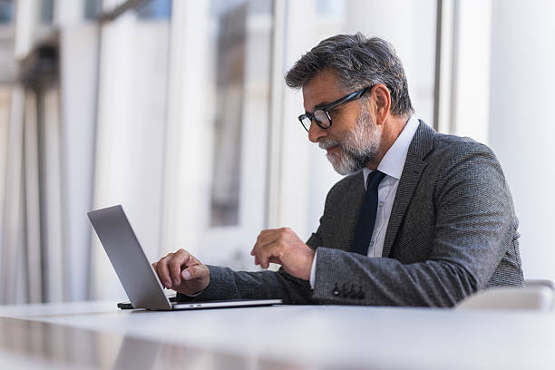 istock Mature businessman working on laptop in modern office 2236285579
