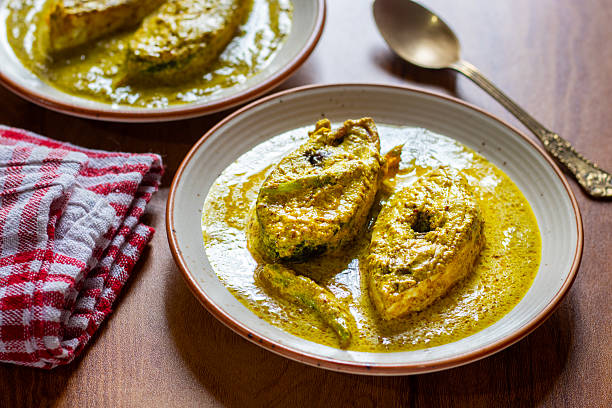 istock Traditional Bengali Hilsa Curry with Mustard Seeds, Aromatic Spices, Rich Flavors, Authentic Taste, Classic River Fish Delicacy, Savory Preparation, Perfect Dish for Special Occasions 2236286397