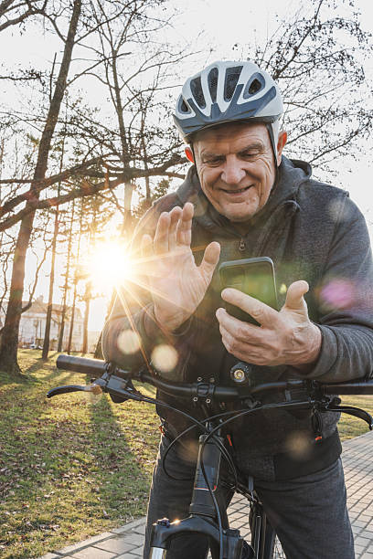 istock Man Making Video Call on Cell Phone While Leaning on Bike in Park 2236289730