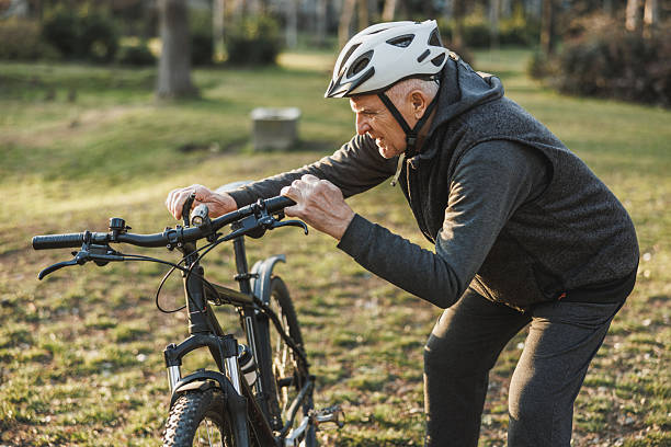 istock Man Adjusting the Handlebars of His Bicycle in a Park 2236289873