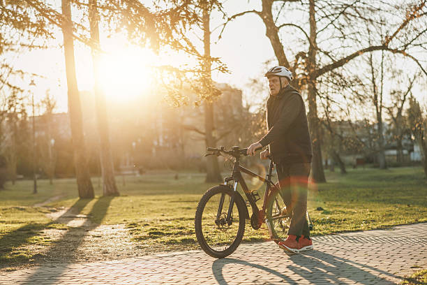 istock Man Walking Next to Bike in Park 2236289987