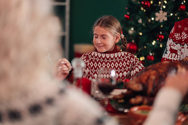 istock Girl praying before christmas dinner with family 2236292496