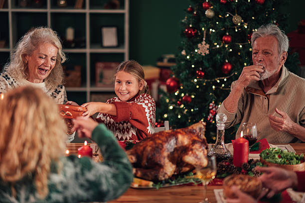 istock Family enjoying christmas dinner together around the table 2236292536