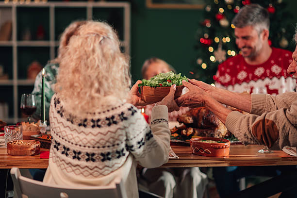 istock Family passing salad bowl at christmas dinner table 2236292570