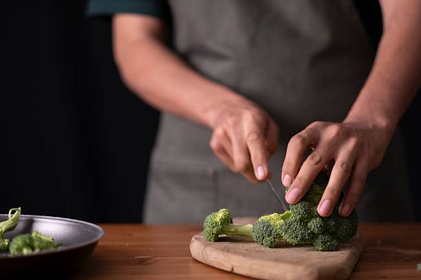 istock Chef hands cutting fresh broccoli preparing healthy meal in a home kitchen 2236295533