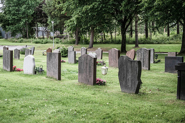 istock Graveyard with headstones among lush green grass and trees.. 2236296397