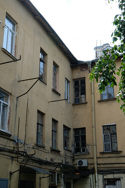 istock Old building courtyard with worn walls and windows in a quiet urban setting during the day 2236303943