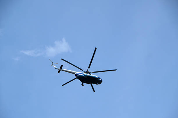 istock Helicopter flies high in the clear blue sky during a sunny afternoon 2236304535