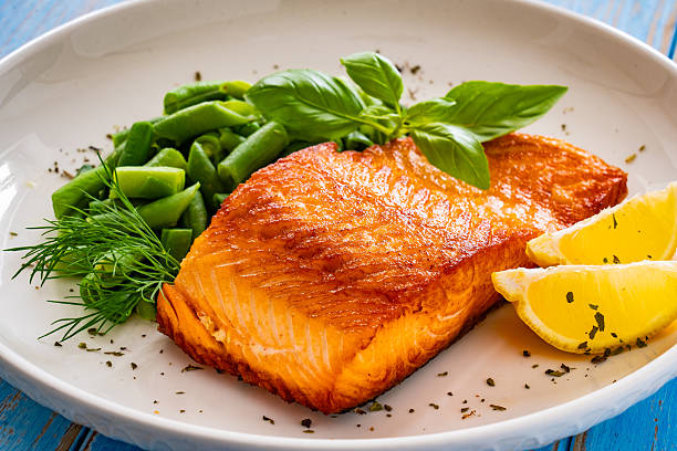 istock Seared salmon steak with boiled green bean on wooden table 2236304899