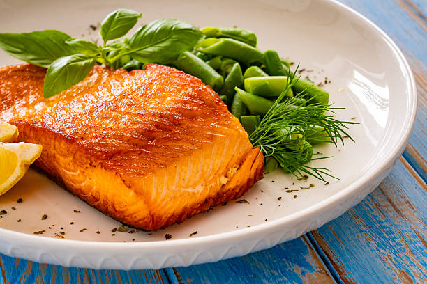 istock Seared salmon steak with boiled green bean on wooden table 2236304903