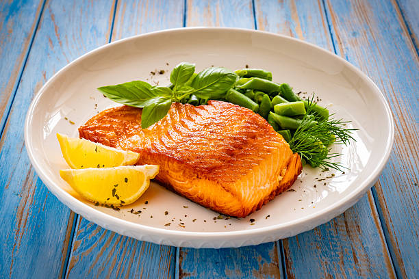 istock Seared salmon steak with boiled green bean on wooden table 2236304921