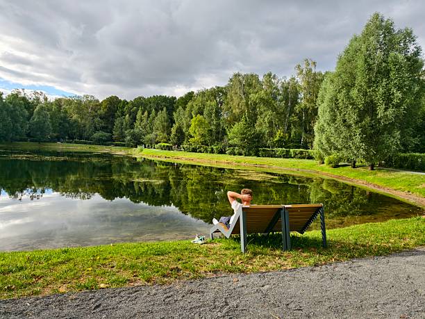 Moscow, Russia - September 01, 2025: Young man relaxing on a bench in Moscow park