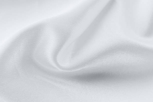 Close-up of flowing white fabric, with soft curves and textures.