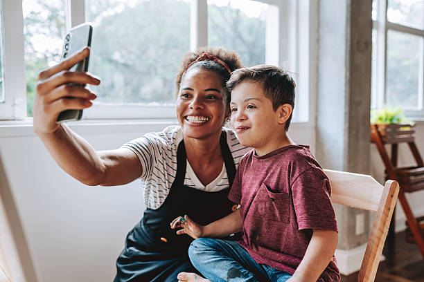 istock Teacher taking a selfie with a child with Down syndrome - painting class on canvas 2236313757