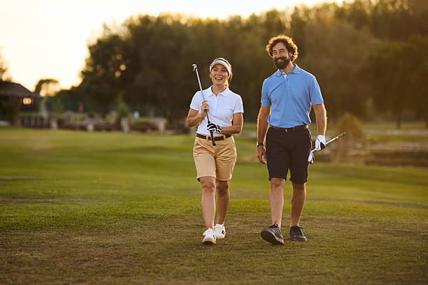 istock Happy golf partners walking across the course at sunset. 2236313826