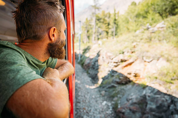 istock Man Looking Out Train Window at Rocky Landscape 2236313876
