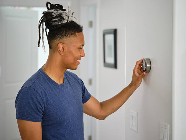istock Young Man Adjusting a Smarthome Thermostat 2236314427