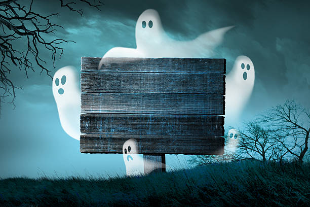 Ghosts fly around an old wooden sign in a spooky forest on Halloween night.