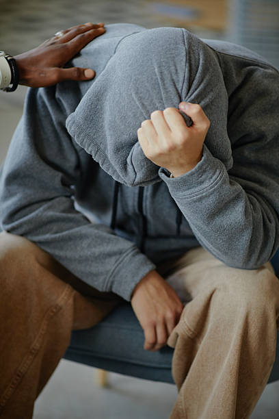 istock Boy Sitting with Head down Receiving Comforting Gesture 2236318548