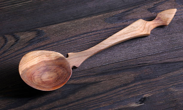 Wooden spoon with a handle in the form of a cat, isolated on a white background. The view from the top