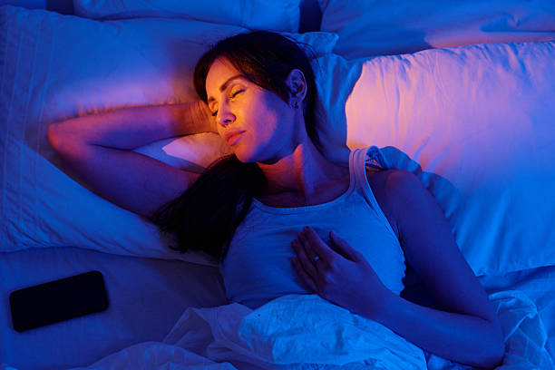 istock Woman Sleeping Peacefully in Bed with Smartphone 2236324991