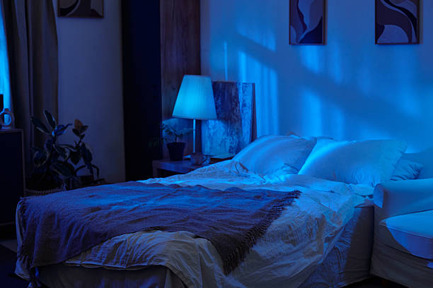 istock Empty Bed in Cozy Bedroom Illuminated by Blue Nighttime Lighting 2236327215