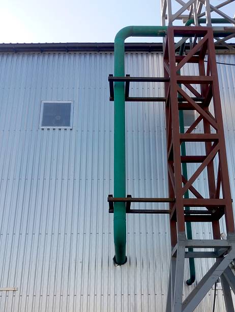 istock Pipeline Supported by a Truss Structure Against a Metal Wall in Industrial Setting 2236327850