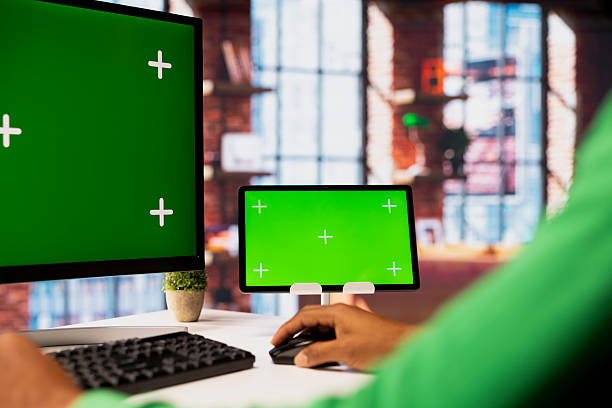 istock Man in home office using isolated screen PC and tablet to work on job tasks 2236328786