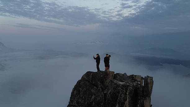 istock Three mountaineers stand on mountain summit 2236328933