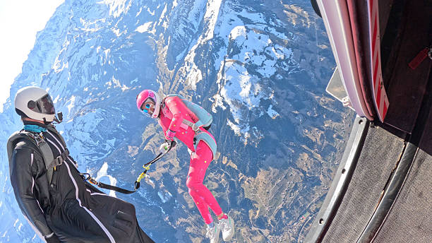 istock Trapeze fliers leave plane, above mountain landscape 2236328999