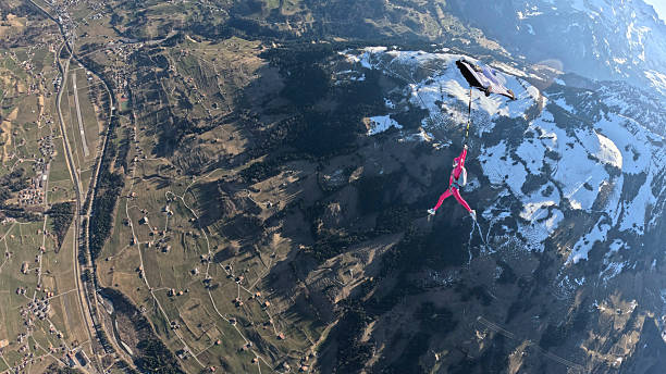 istock Trapeze fliers leave plane, soar above mountain landscape 2236329059