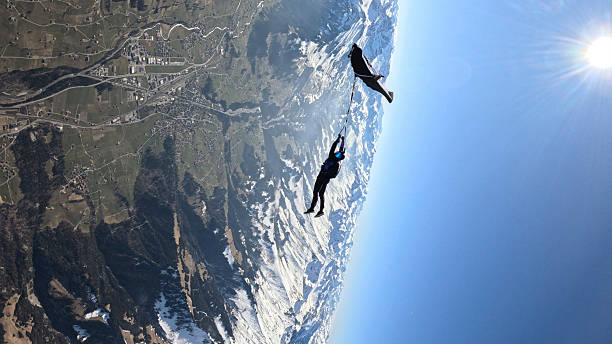 istock Trapeze fliers leave plane, soar above mountain landscape 2236329069