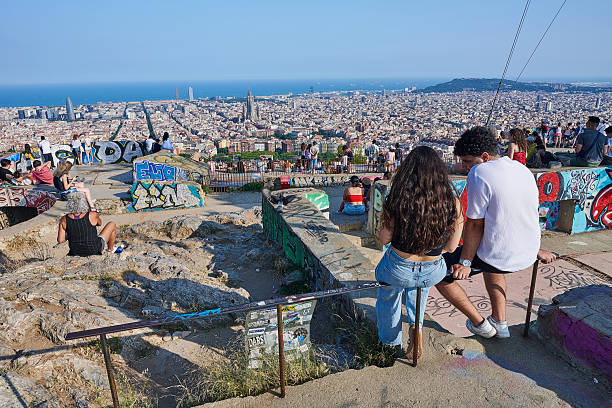 Barcelona, Spain - June 09, 2025: tourists and local people enjoy a sunny afternoon overlooking Barcelona cityscape from the terrace of Bunkers del Carmel, a hill-side location in Horta-Guinardo district.