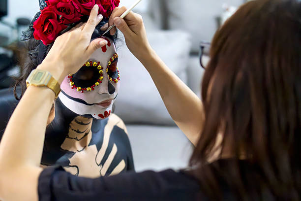 Make-up artist painting a catrina