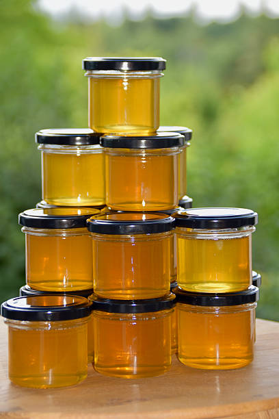 istock Stack of clear glass jars filled with golden honey 2236331859